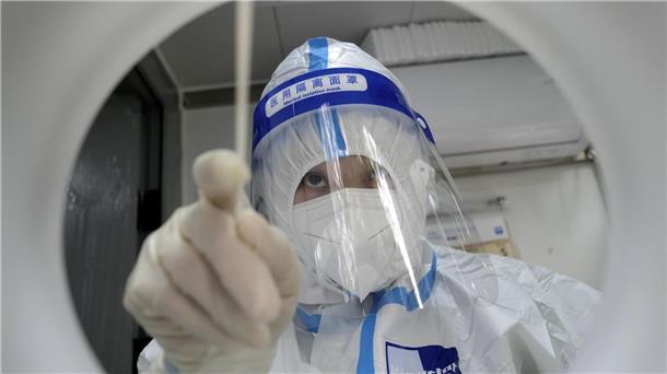 Reisende aus China: Wann ist der Beginn für die Testpflicht? Ein medizinischer Mitarbeiter in Schutzkleidung während er einen PCR-Test zum Nachweis des Coronavirus durchführt.