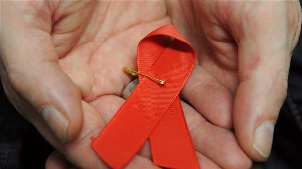 Australien könnte HIV-Epidemie bald besiegt haben Ein mit dem HI-Virus infizierter Mann mit einer roten Schleife als Symbol der Solidarität mit HIV-Positiven und Aids-Kranken.