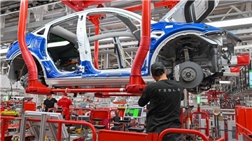 Ein Mitarbeiter arbeitet im Tesla-Werk Berlin Brandenburg an einer Fertigungslinie für Elektrofahrzeuge vom Typ Model Y.