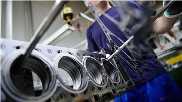 Ein Mitarbeiter eines Autozulieferers kontrolliert die Produktion der Zylinderkopfdichtungen.