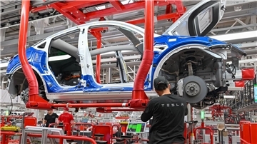 Ein Mitarbeiter im Tesla-Werk in Grünheide an einer Fertigungslinie für Elektrofahrzeuge vom Typ Model Y.
