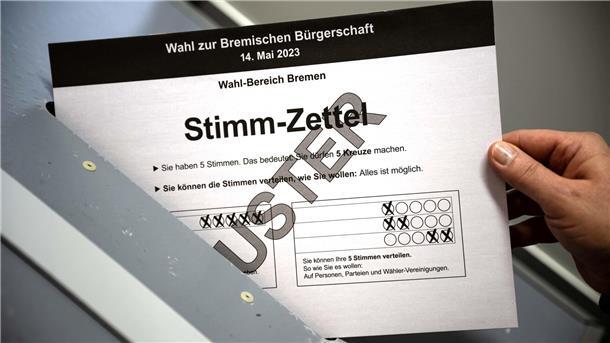 Neue Umfrage: Die CDU schließt im Land Bremen zur SPD auf Ein Muster von einem Stimmzettel für die Wahl zur Bremischen Bürgerschaft wird  in eine Wahlurne geworfen. Jetzt, zwei Wochen vor der Wahl,  wurde eine neue Umfrage veröffentlicht.