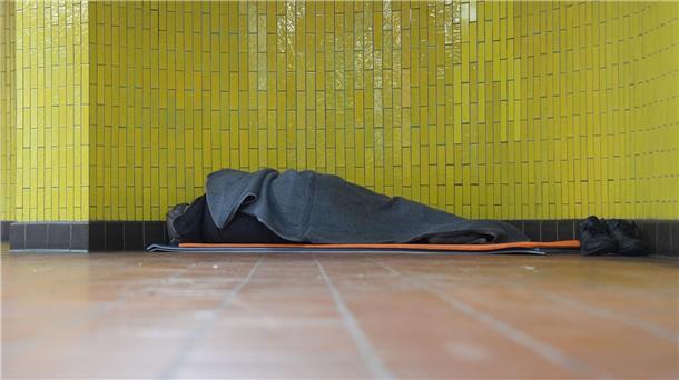 Ein Obdachloser liegt in seinem Schlafsack in einer U-Bahnstation in der Hamburger Innenstadt. 17,7 Millionen Menschen waren 2023 in Deutschland von Armut oder Ausgrenzung bedroht.