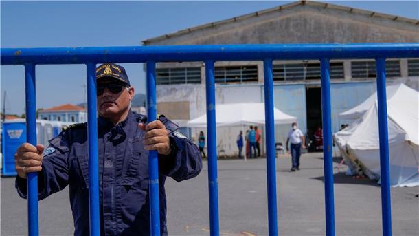 Unglück im Mittelmeer: Keine Hoffnung auf mehr Überlebende Ein Offizier der Küstenwache am Eingang des Flüchtlingslagers nahe Athen.