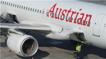 Ein Passagierflugzeug der Austrian Airlines steht an einem Terminal des Flughafens Hamburg Airport.