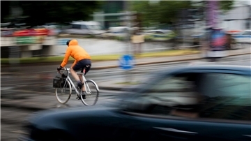 Ein Pkw fährt hinter einem Fahrradfahrer an einer Kreuzung einer Hauptverkehrsstraße in Berlin. Inwieweit Maßnahmen zur Verbesserung der Verkehrssicherheit befürwortet werden, hängt auch stark vom Alter ab.