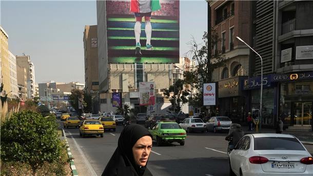 Prominenter Blogger Ronaghi im Iran auf Kaution freigelassen Ein Plakat zeigt einen Fußballspieler mit der Nationalflagge an einem Gebäude in Teheran.
