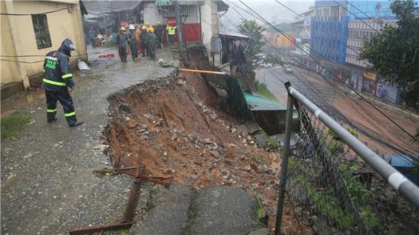 Taifun „Doksuri“ wütet auf den Philippinen Ein Polizist inspiziert einen durch den Taifun „Doksuri“ verursachten Erdrutsch in einem Wohngebiet in Baguio City.