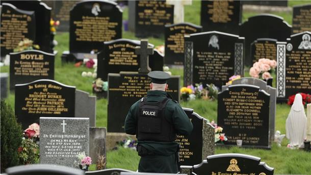 Nordirland: Polizei entdeckt mutmaßliche Rohrbomben Ein PSNI-Polizist patrouilliert auf dem Stadtfriedhof von Londonderry. Kurz vor der Ankunft von US-Präsident Biden in Nordirland fand die Polizei dort vier mutmaßliche Rohrbomben.