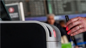 Ein QR-Code mit Reisedaten wird vom Scanner des Check-in-Automaten gelesen.
