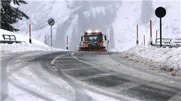 Ein Räumfahrzeug des Winterdienstes fährt auf dem Riedbergpass im Schneetreiben.