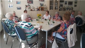 Senioren sitzen an einem Tisch.