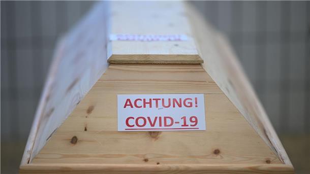 Ein Sarg mit der Aufschrift „Achtung! Covid-19“ in einem Raum im Krematorium, bevor der Sarg eingeäschert wird.