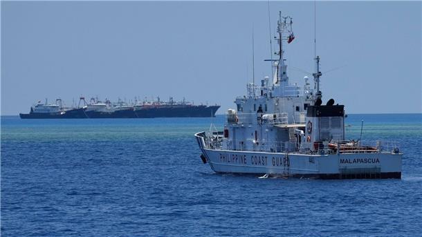 Philippinen werfen China „aggressive Taktiken“ vor Ein Schiff der philippinischen Küstenwache nähert sich einigen der vielen mutmaßlichen chinesischen Milizschiffe an dem von den Philippinen beanspruchten Riff namens Whitsun.