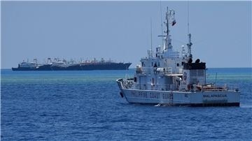 Ein Schiff der philippinischen Küstenwache nähert sich einigen der vielen mutmaßlichen chinesischen Milizschiffe an dem von den Philippinen beanspruchten Riff namens Whitsun.