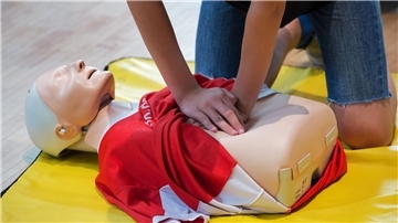Ein Schüler trainiert eine Herzdruckmassage an einer speziellen Übungspuppe.