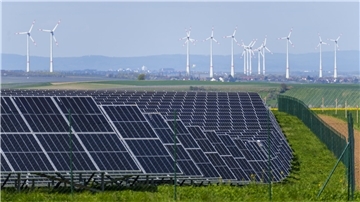 Ein Solarpark steht in unmittelbarer Nähe zu mehreren Windkraftanlagen. Mit Blick auf die Klimakrise ist Hoffnung nicht das erste Wort, das einem bei diesem Anblick in den Sinn kommt. Und doch scheint die Rettung der Welt auch davon abzuhängen.