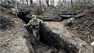 Ein Soldat der ukrainischen Streitkräfte steht in einem Graben.