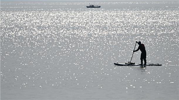 Ein Stand-up-Paddler paddelt über den Bodensee. (Symbolbild)