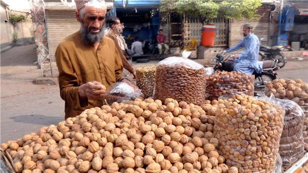 Ein Straßenhändler verkauft im pakistanischen Hyderabad Nüsse und Trockenfrüchte. Die Nachfrage nach Trockenfrüchten ist mit dem Beginn der Kältewellen der Wintersaison gestiegen.