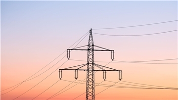 Ein Strommast bei Sonnenaufgang.