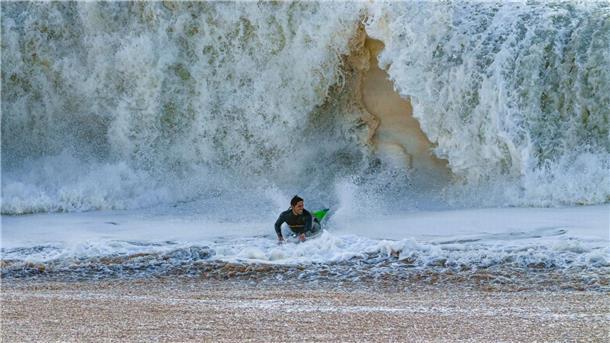 Ein Surfer taucht in Seal Beach aus den Wellen auf.
