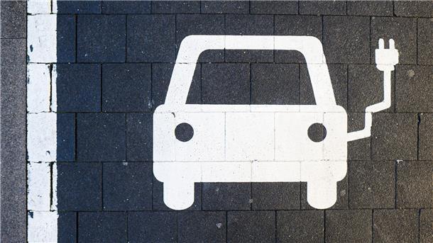 Ein Symbol markiert einen Parkplatz an einer Ladesäule für Elektroautos.