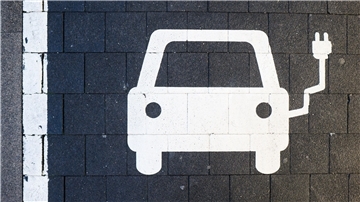 Ein Symbol markiert einen Parkplatz an einer Ladesäule für Elektroautos.