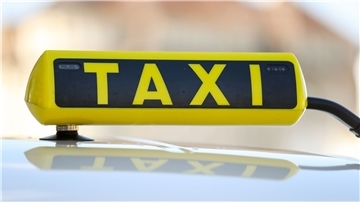 Ein Taxischild an einem Wagen.