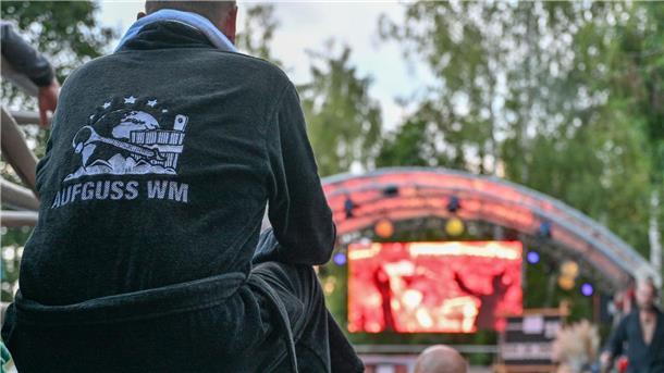 Heißer Wettbewerb: Sieger der Sauna-Aufguss-WM stehen fest Ein Teilnehmer der Aufguss-Weltmeisterschaft 2023 verfolgt auf einer Videoleinwand einen Auftritt der Konkurenz.