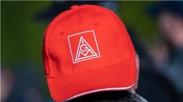 Ein Teilnehmer einer Kundgebung der Gewerkschaft IG Metall trägt während eines Warnstreiks eine Mütze mit dem Logo der IG Metall.