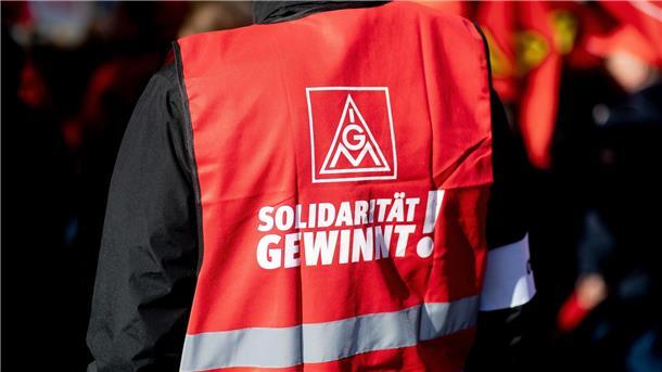 IG Metall ruft zu weiteren Warnstreiks im Norden auf Ein Teilnehmer einer Kundgebung der IG Metall trägt eine rote Weste mit der Aufschrift „Solidarität gewinnt!“.
