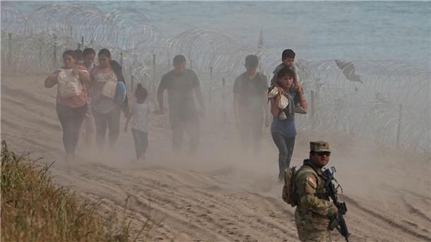 Rund 250.000 Migranten passierten Darién-Dschungel Ein texanischer Wachmann neben Menschen, die den Rio Grande von Mexiko aus in die USA überquert haben.