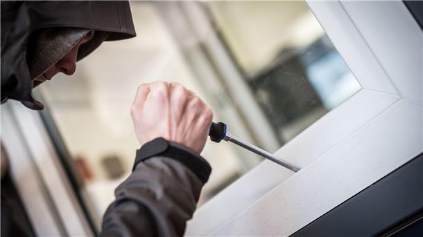 Urlaubszeit ist Einbruchszeit: So schützen Sie Ihr Zuhause  Ein Einbrecher hebelt mit einem Schraubendreher ein Fenster auf