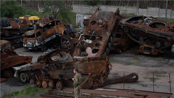 Ein ukrainischer Soldat steht neben zerstörten russischen Panzern in Lyman.