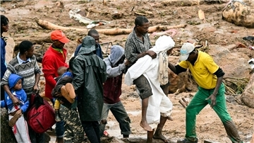 Ein verletzter Mann wird in Malawi über eine Behelfsbrücke getragen.