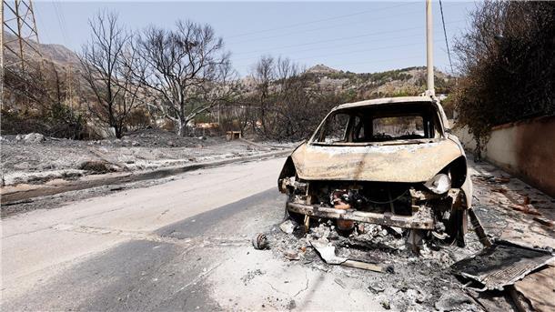 Südeuropa: Viele Brände unter Kontrolle Ein vom Feuer zerstörtes Auto auf einer Landstraße auf Sizilien.