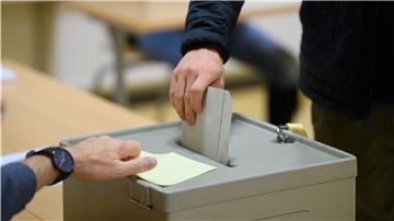Ein Wähler wirft bei der Stimmabgabe zur Bundestagswahl im Wahllokal seinen Stimmzettel in eine Wahlurne.