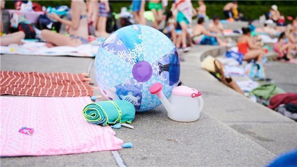 Lage bei Straftaten in Freibädern unauffällig Ein Wasserball und Handtücher liegen in einem Schwimmbad am Beckenrand.