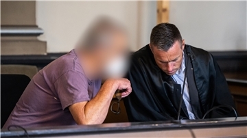 Ein wegen zweifachen Mordes und versuchten Mordes angeklagter Mann sitzt kurz vor Prozessfortsetzung in einem Gerichtssaal des Landgerichts Verden und unterhält sich mit seinem Pflichtverteidiger Jakob Struif (rechts).