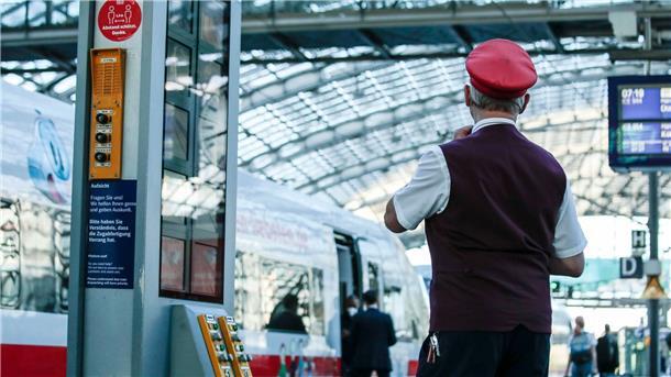 Rock oder Sakko? Bahn stellt Wahl der Uniform frei Ein Zugbegleiter gibt ein Abfahrtszeichen für einen ICE auf dem Bahnsteig im Berliner Hauptbahnhof.