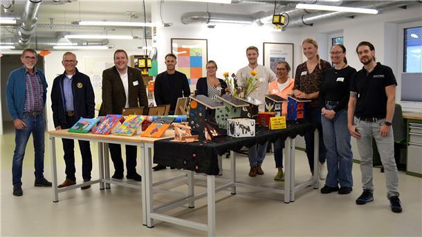 Zehn Besucher stehen rund um einen Tisch mit Dingen, die in der Werkstatt des Vördewerks gefertigt wurden.