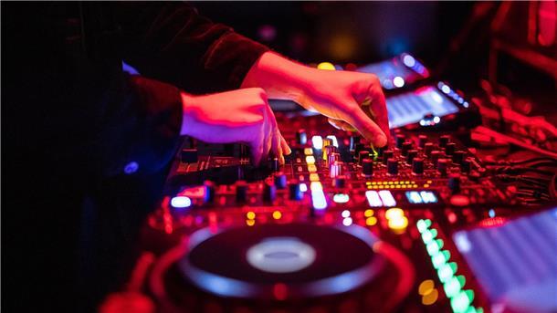 Großer Andrang bei U18-Partys ohne Alkohol in Lüneburg  Ein DJ steht in einem Club am Mischpult.