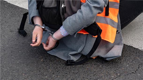 Polizeichefin: Staatliche Gewalt gegen Blockierer geht Eine Aktivistin der Gruppe Letzte Generation sitzt mit Handschellen auf einer Kreuzung in Berlin (Symbolbild).