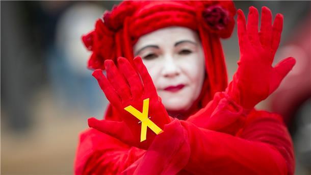 Grüne unterstützen Einsatzreserve für Atomkraftwerke Eine Aktivistin von Extinction Rebellion zeigt ein gelbes Kreuz während einer Performance vor Beginn des Bundesparteitags der Grünen im World Conference Center.