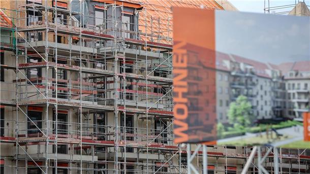 Eine Bautafel steht vor der Baustelle mehrerer Miethäuser. Der Städtetag fordert mehr Wohnungsbau.