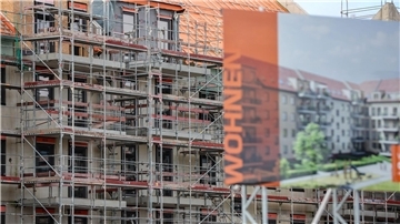 Eine Bautafel steht vor der Baustelle mehrerer Miethäuser. Der Städtetag fordert mehr Wohnungsbau.
