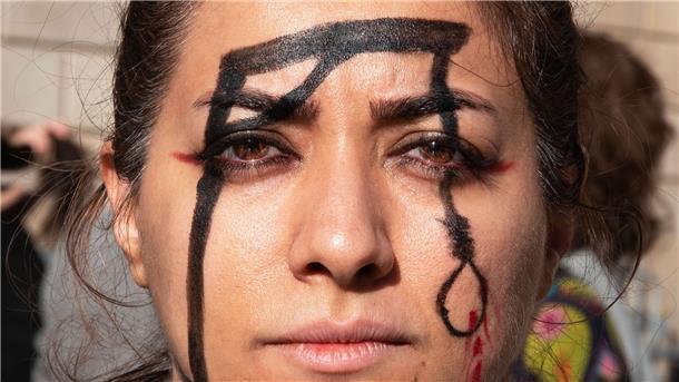 Eine Demonstrantin in Barcelona hat einen Galgen auf ihr Gesicht gemalt, um an die Hinrichtung von Mohsen S. zu erinnern.