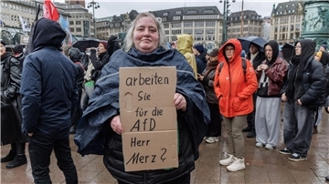 Demos gegen Merz-Äußerung - „Friedrich“-Protestsong Eine Demonstrantin in Hamburg stellt auf einem Pappschild eine Frage an Bundeskanzler Friedrich Merz (CDU).