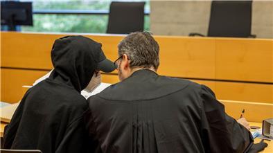 Eine der beiden Angeklagten (l) unterhält sich mit ihrem Rechtsanwalt im Sitzungssaal im Landgericht.